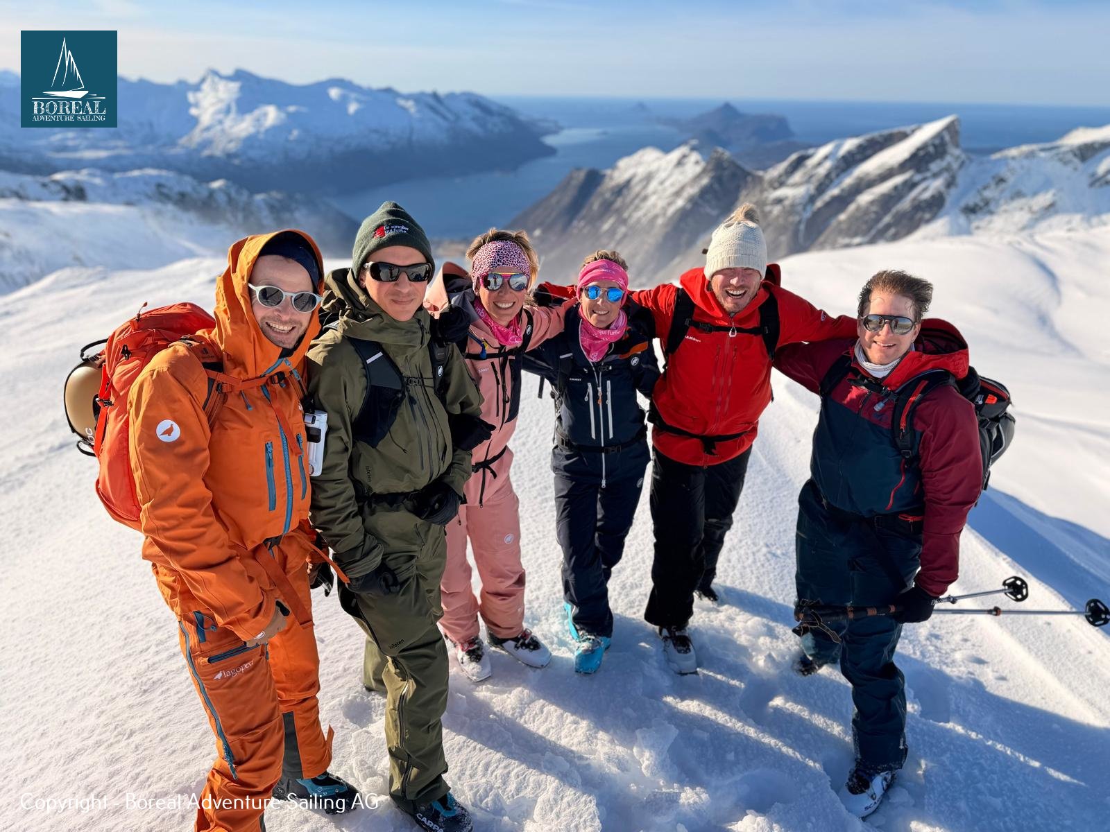 Ski & Sail, Bodø & Lofoten: group of six ski tourers smiling on a summit above the fjord