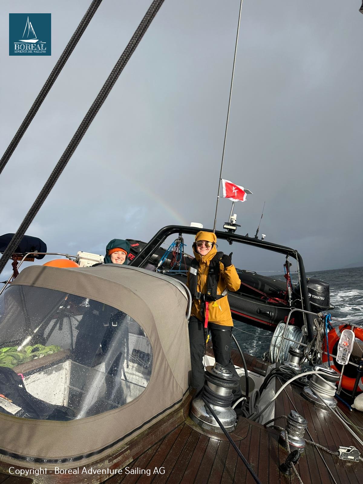Ski & Sail, Bodø & Lofoten: guest in the cockpit while sailing under grey skies