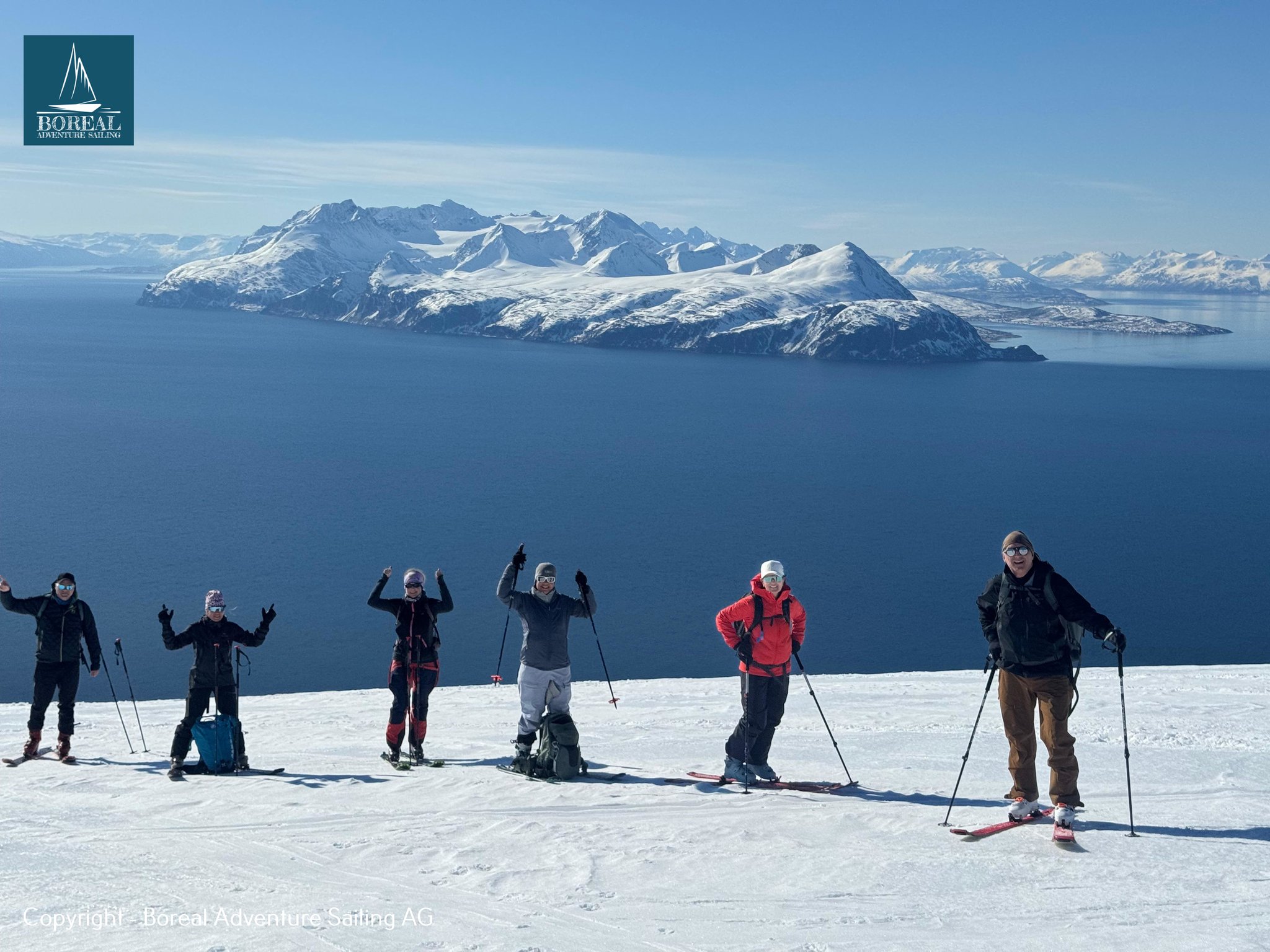 Ski & Sail, Lyngen Alps: ski group celebrating on a summit above the fjord