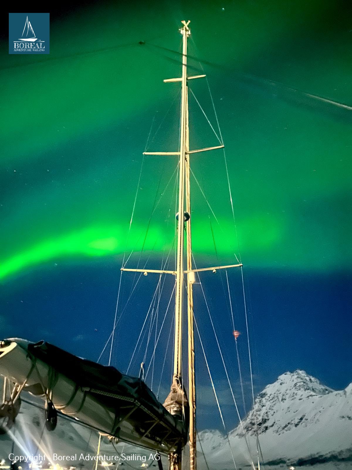 Ski & Sail, Lyngen Alps: green northern lights above the yacht's mast and rigging