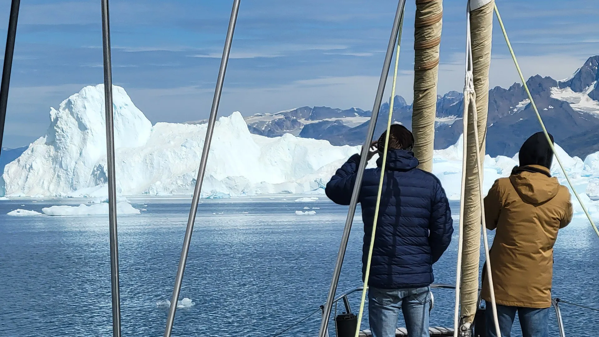 Voile & Exploration, Groenland de l’Est : participants sur le pont avant contemplant icebergs et sommets acérés