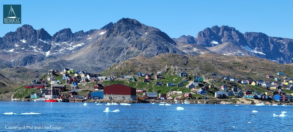 Sail & Explore, East Greenland: colourful houses of an East Greenland village below jagged mountains