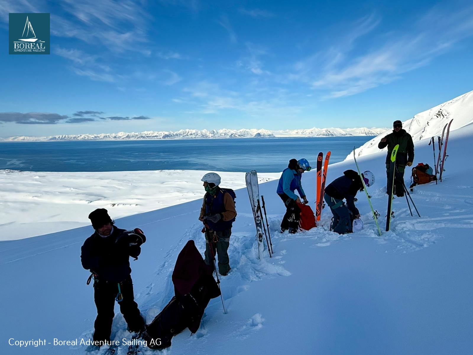 Ski & Sail, Svalbard: ski group getting ready on a ridge high above the sea