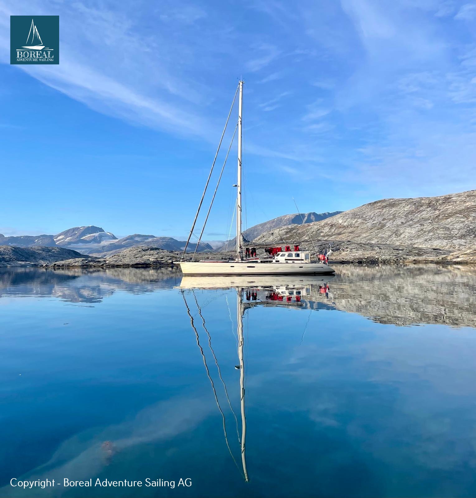 Sail & Explore, East Greenland: yacht at anchor mirrored in a glassy East Greenland fjord
