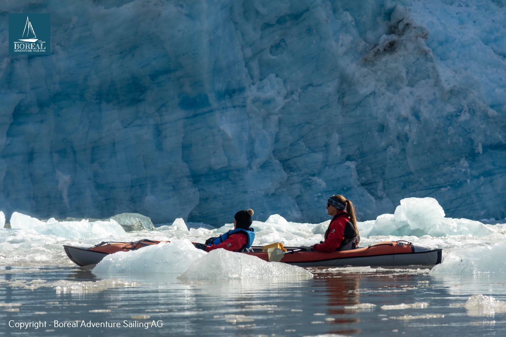 Sail & Kayak, Svalbard: tandem kayak among floating ice before a deep-blue glacier wall
