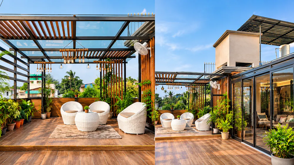 Rooftop terrace lounge with wooden pergola, white wicker seating, potted plants, and open sky views.