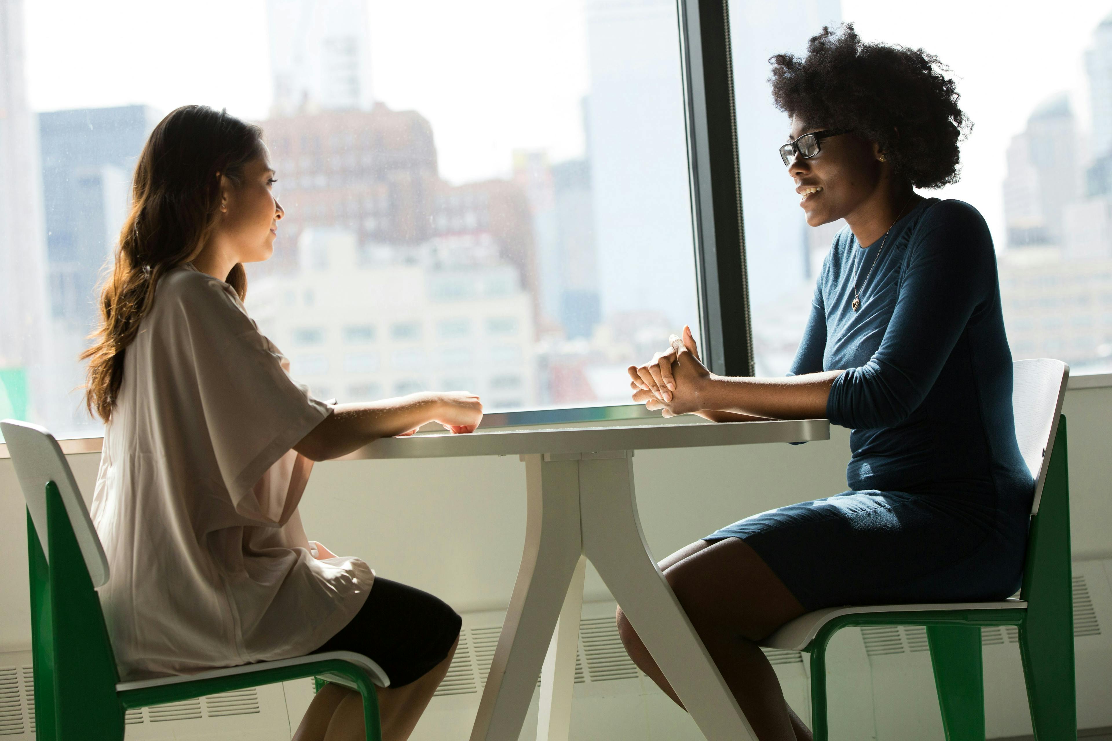 two women at a table talking