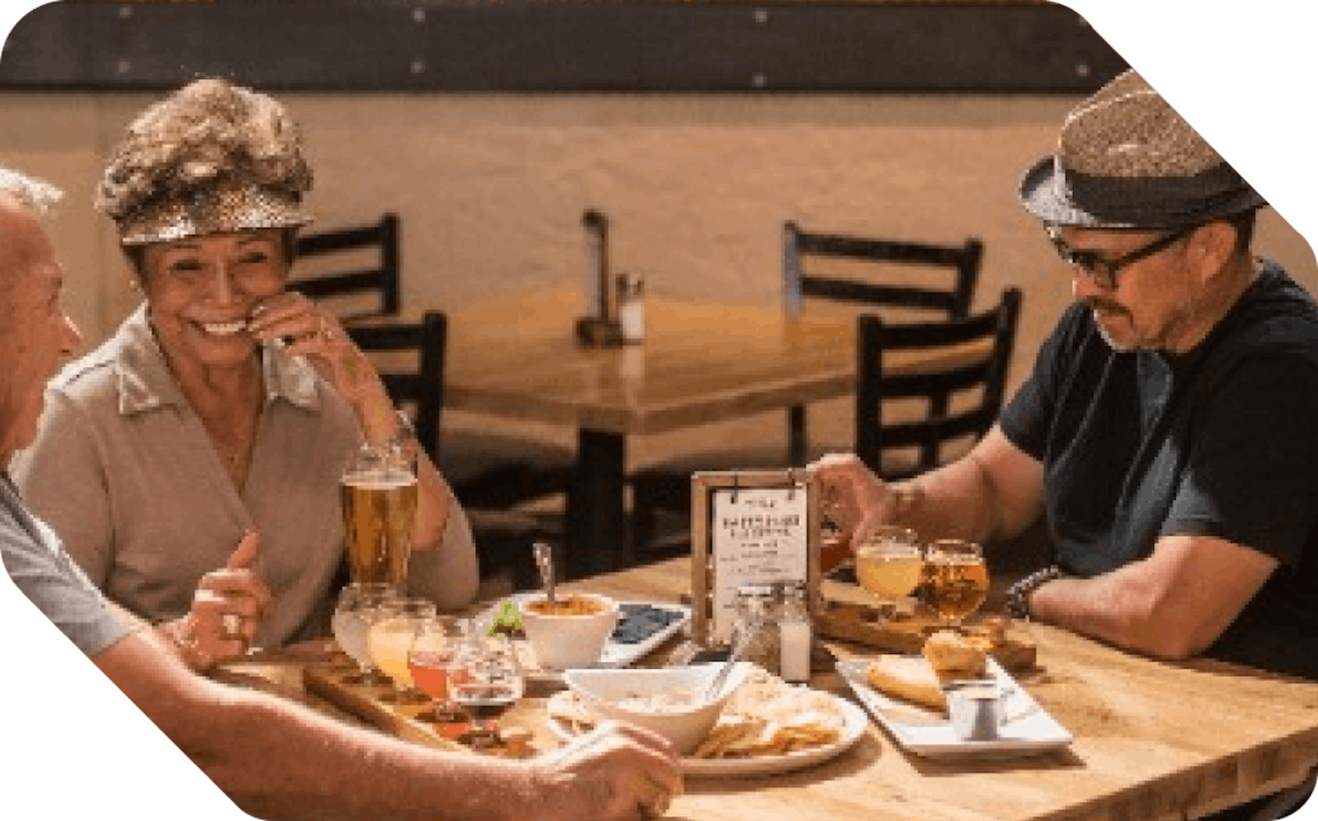 Smiling people sitting around table and eating