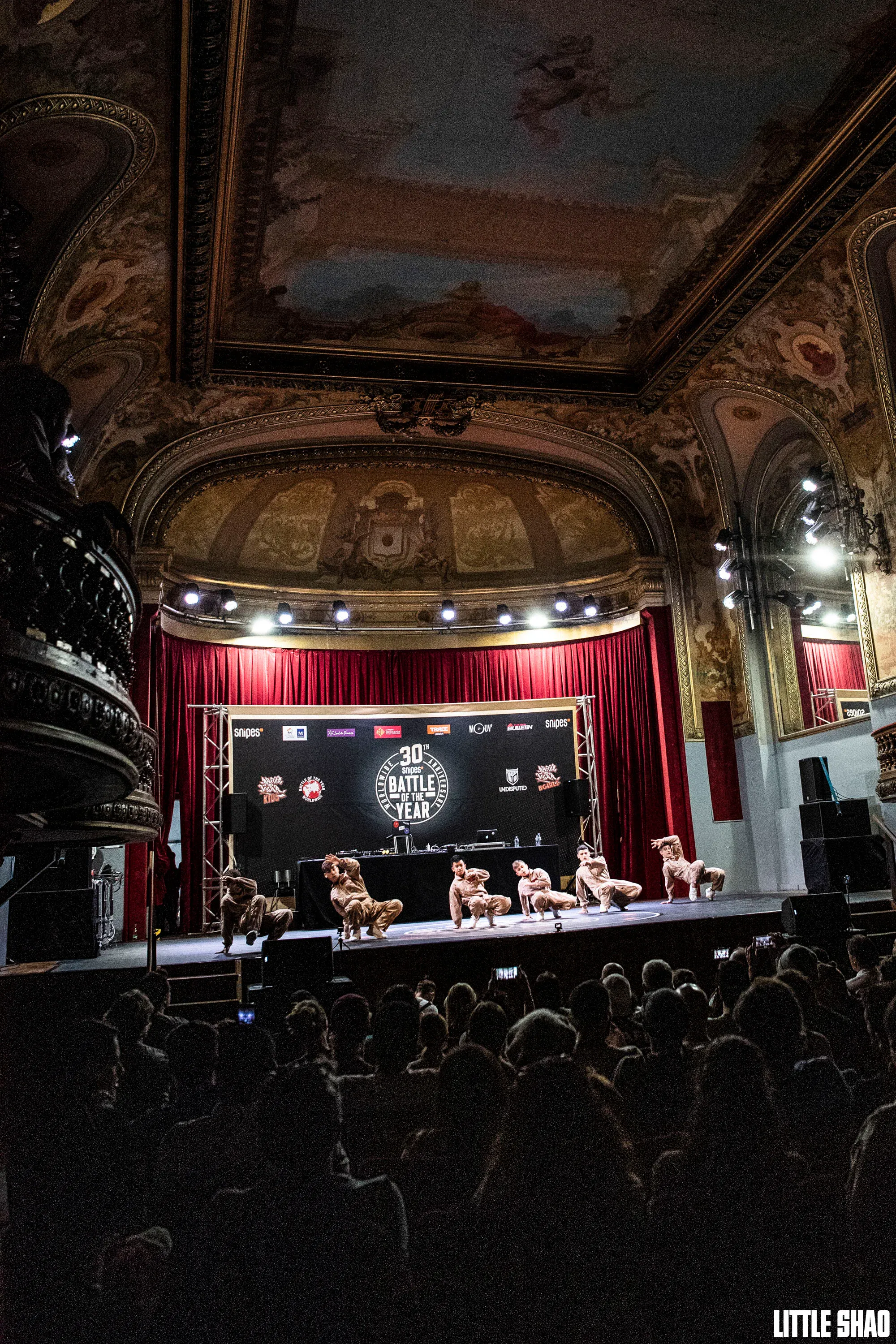 Vue large théâtre baroque + scène + public, signature
