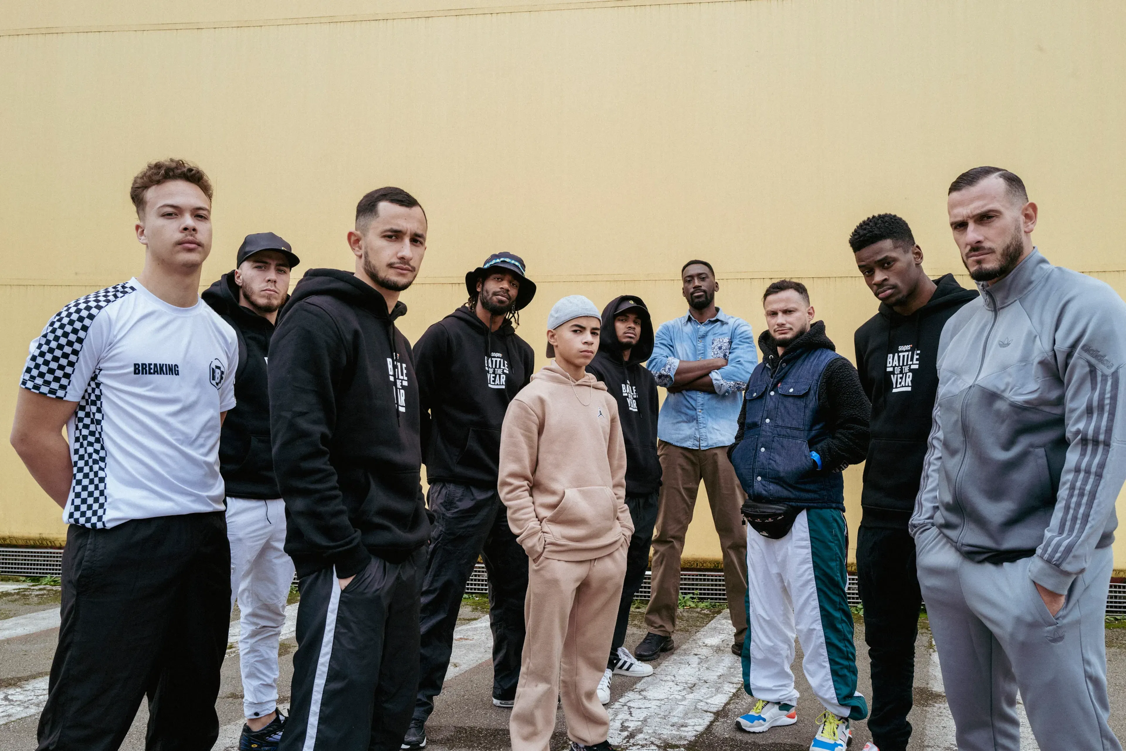 Crew complet horizontal, mur jaune chaud, palette nette, identité forte