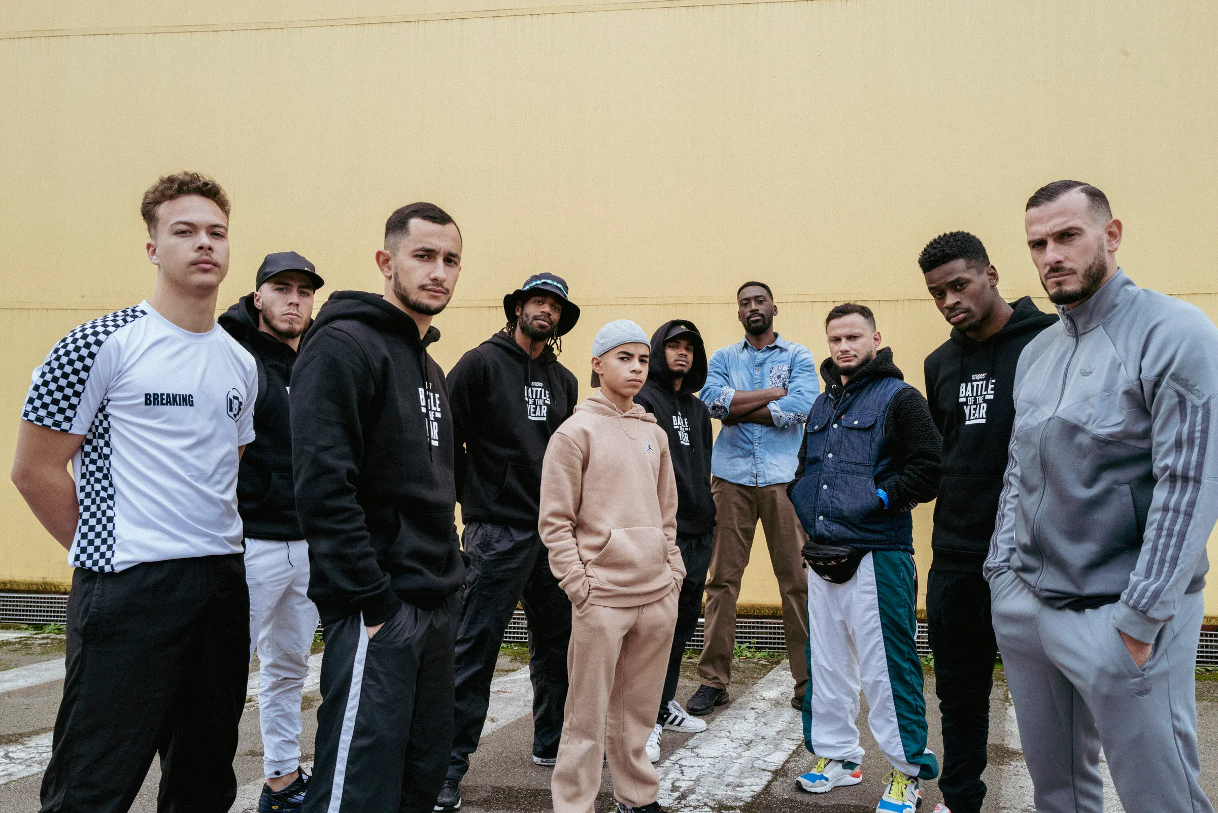 Crew complet horizontal, mur jaune chaud, palette nette, identité forte