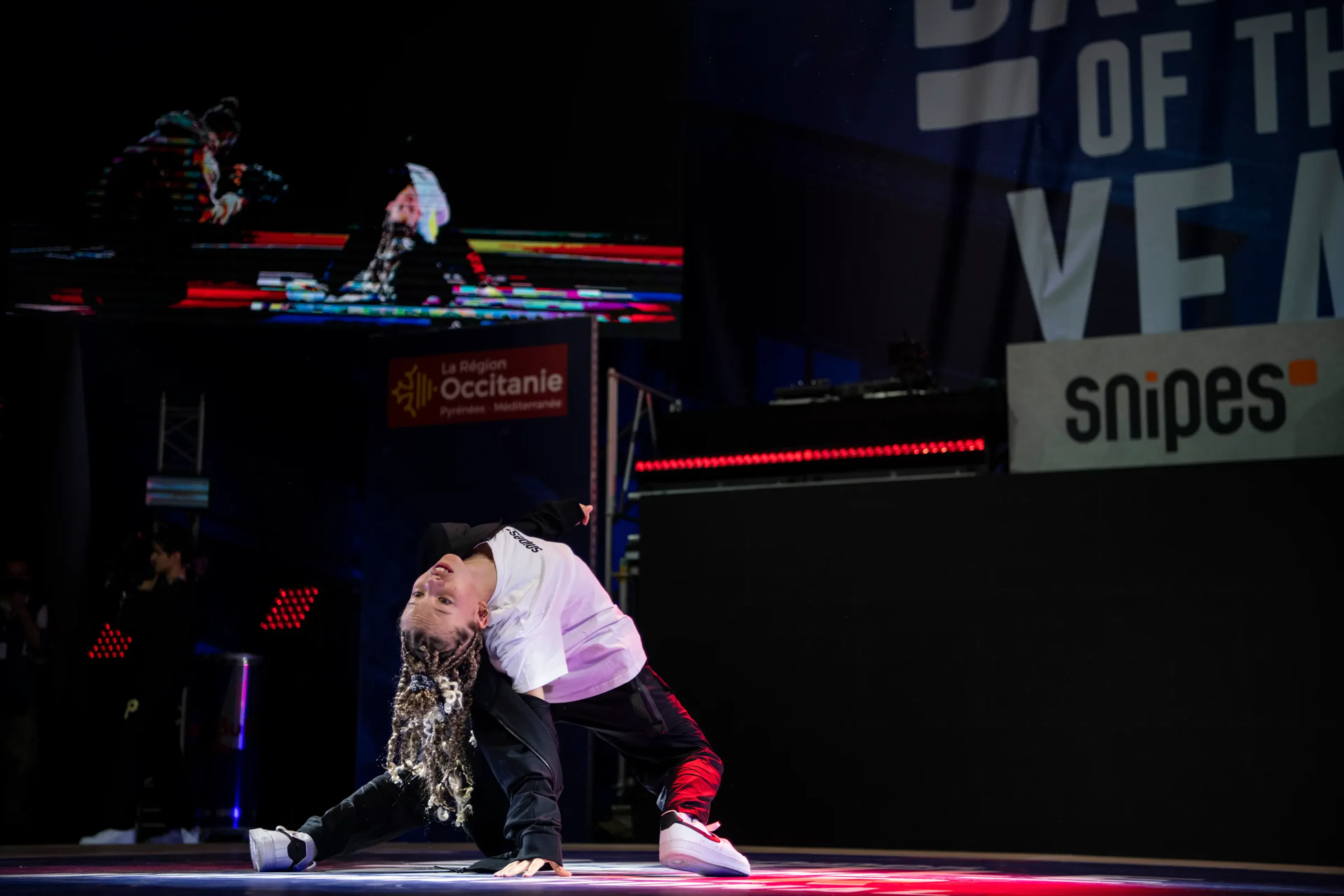 B-girl tresses, freeze cambré, écran retransmission, identité forte
