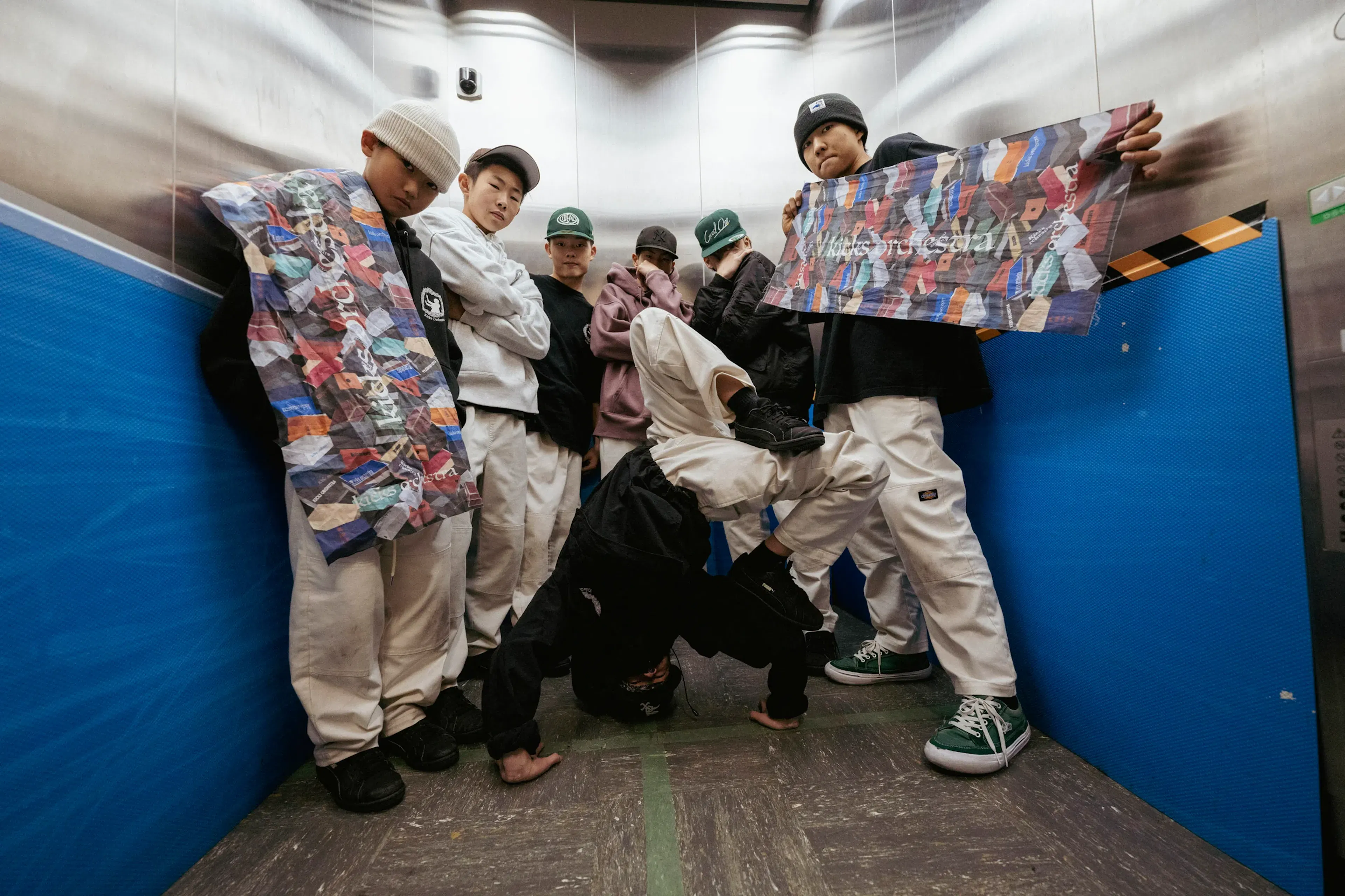 Crew dans ascenseur avec freeze, scène intime forte