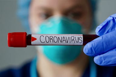 Scientist holding coronavirus test tube