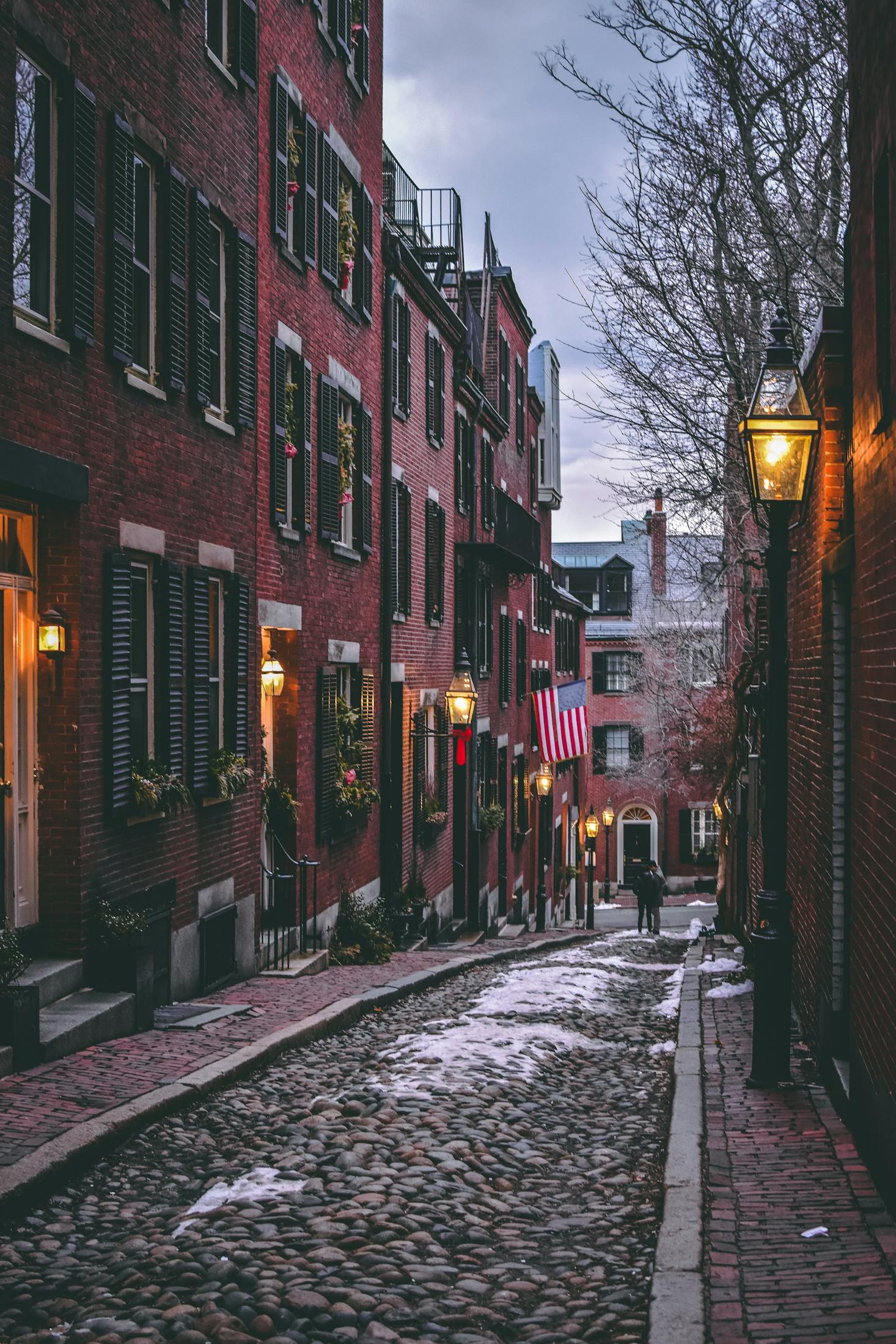 Brick buildings with shutters line cobblestone streets near Rowes Wharf, Boston