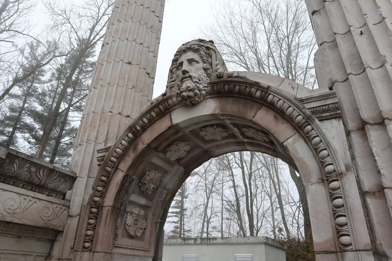 A stone monument with a carved face seen against a grey sky in Scarborough, Ontario