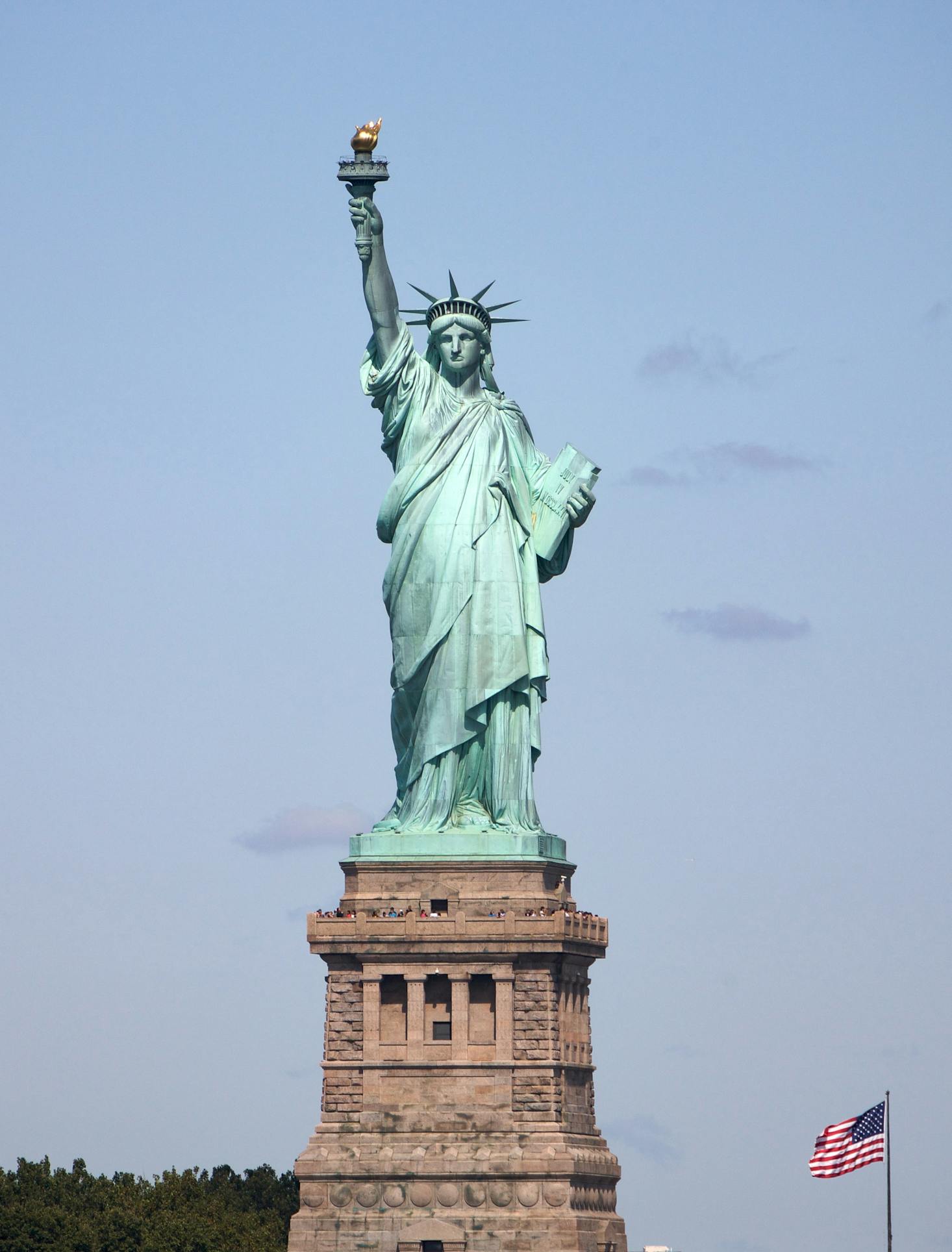 The green Statue of Liberty in New York Harbor on a sunny day