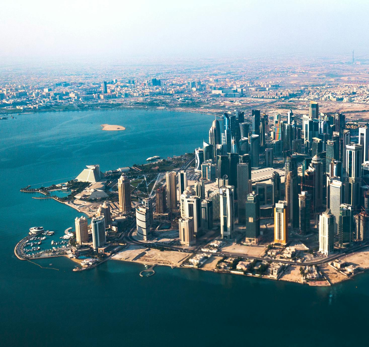 Numerous tall skycrapers overlook the water in Doha, Qatar