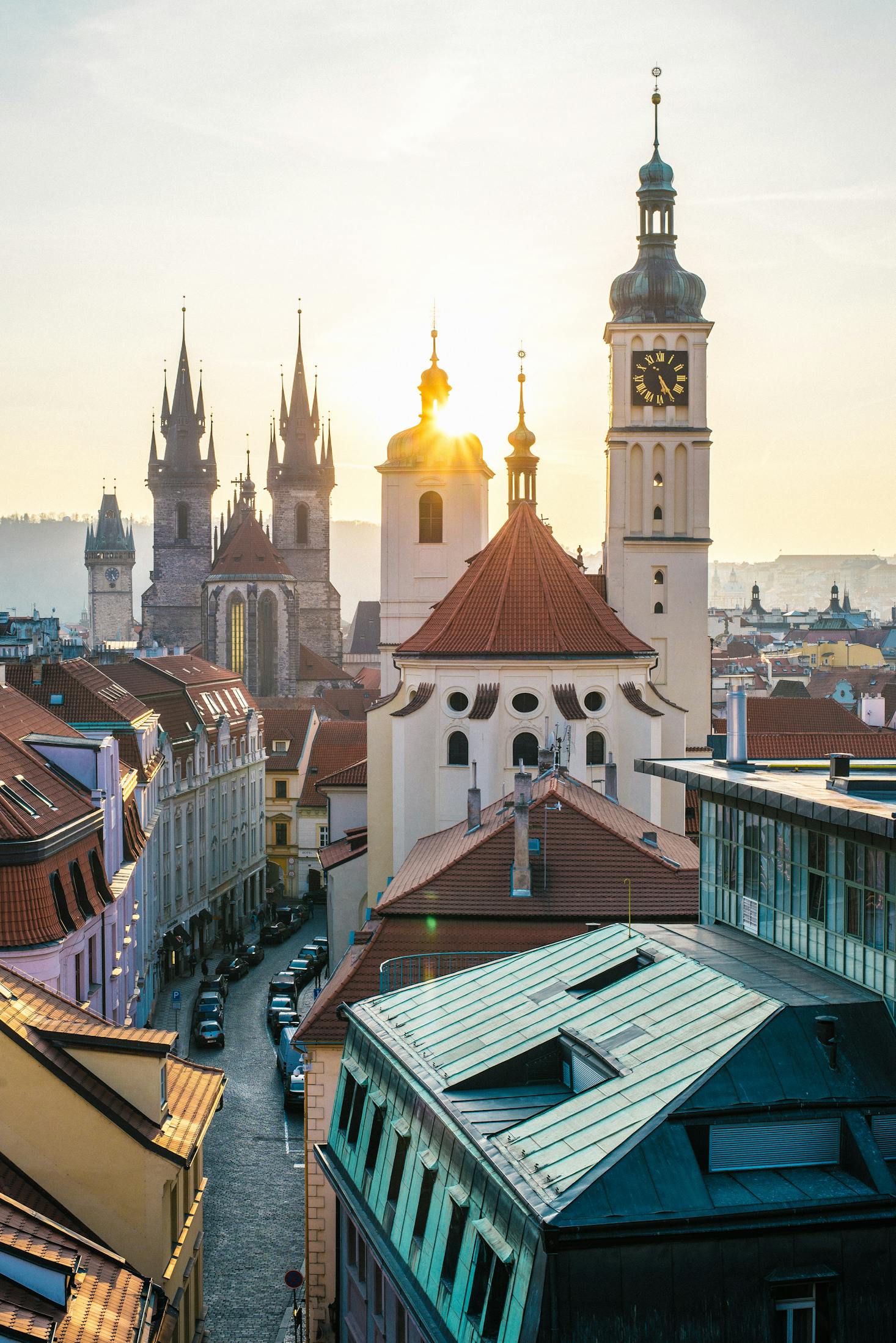 Ornate buildings on Castle Hill in Prague with the sun shining through the towers