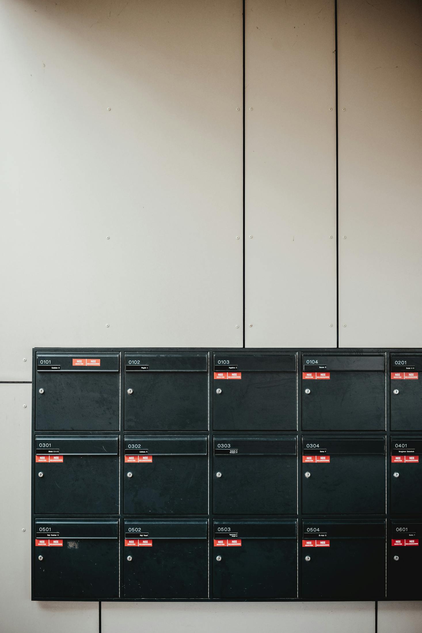 Black mailboxes on a plain wall