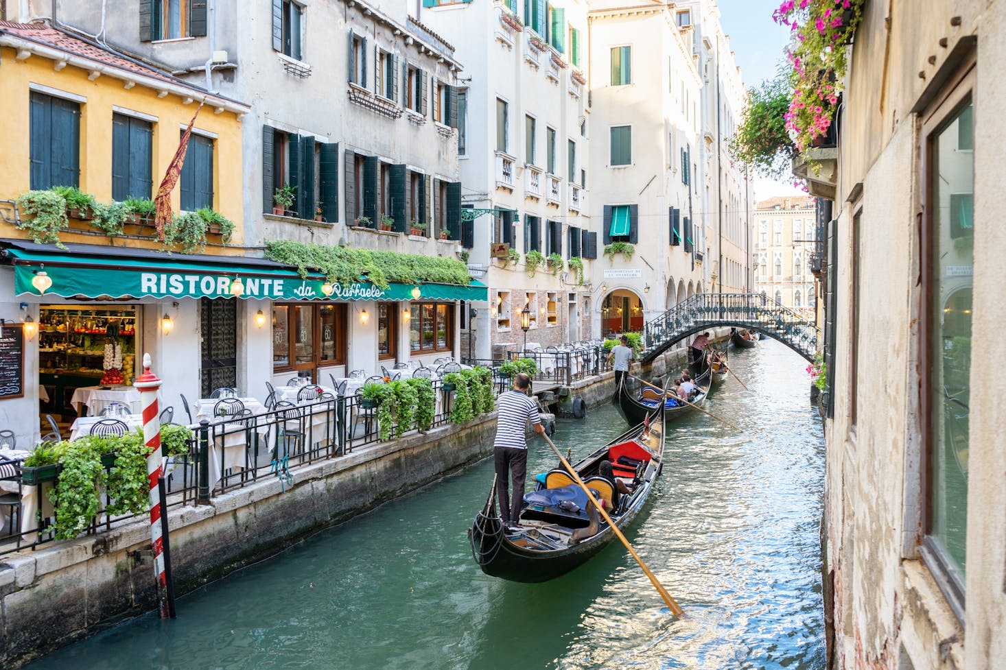 Gondolas passing a restaurant in Venice