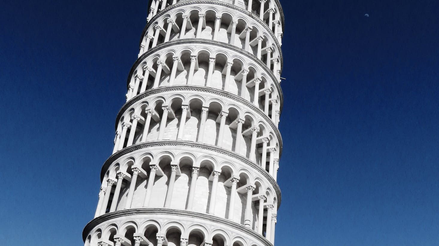 Leaning Tower of Pisa, a white structure set against a dark blue sky