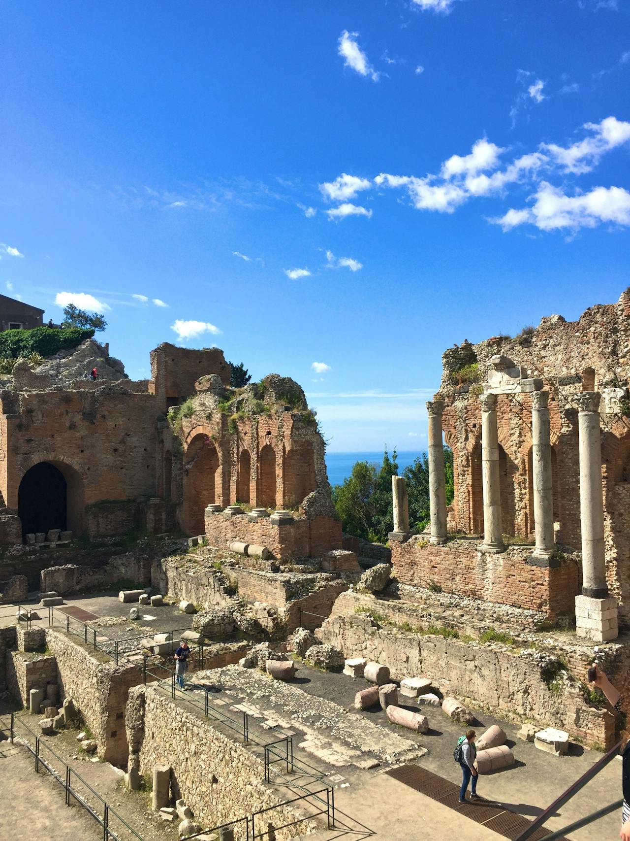 The ancient amphitheater in Taormina, Italy with a blue sky backdrop The ancient amphitheater in Taormina, Italy with a blue sky backdrop