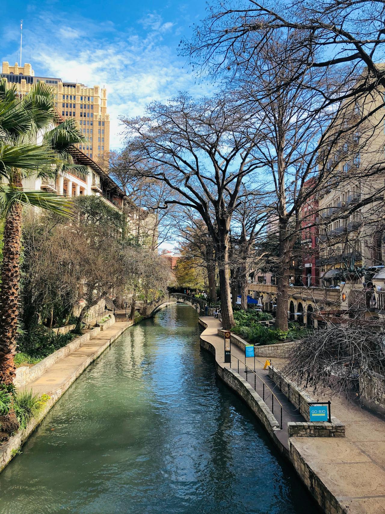 Cement buildings, trees and walkways line a waterway in San Antonio, Texas Cement buildings, trees and walkways line a waterway in San Antonio, Texas