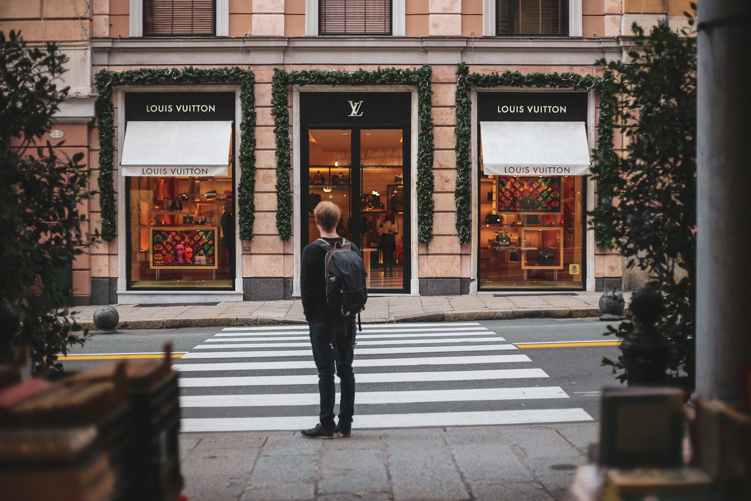 A man with red hair standing across the Louis Vuitton store in Genoa