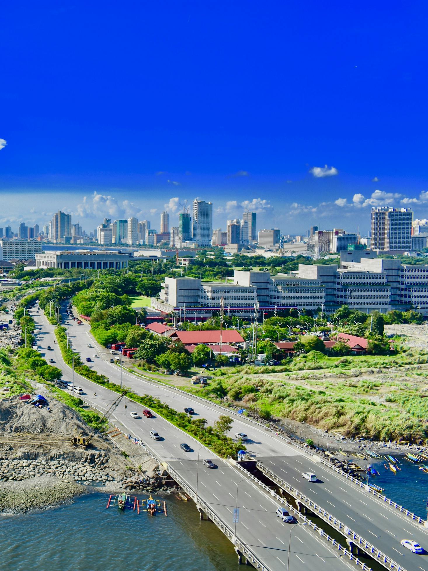 The skyline of Manila, Philippines, with highrises pictures against a bright blue sky