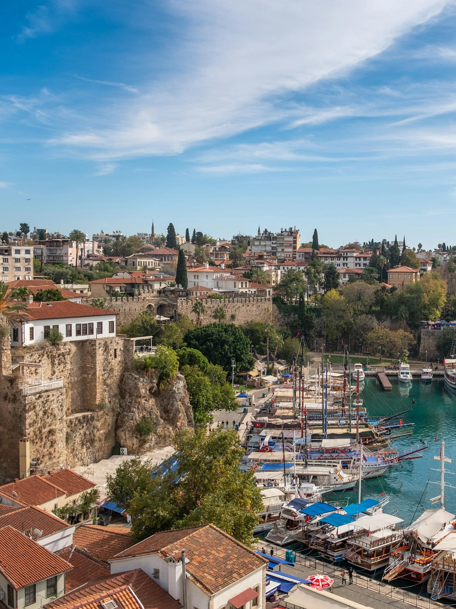 Buildings overlook boats on turquoise waters in Antalya, Turkey