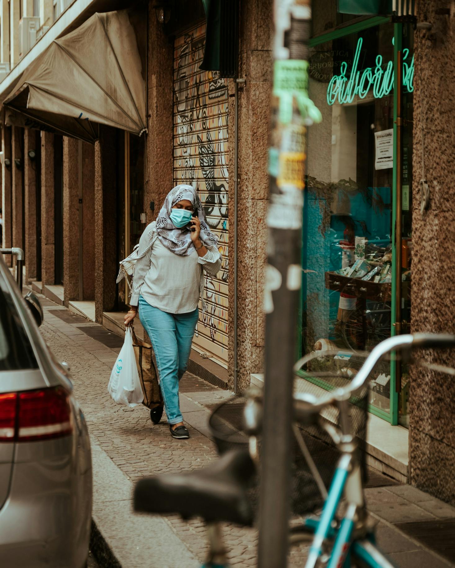 A woman carrying shopping bags on the street in Bologna, Italy