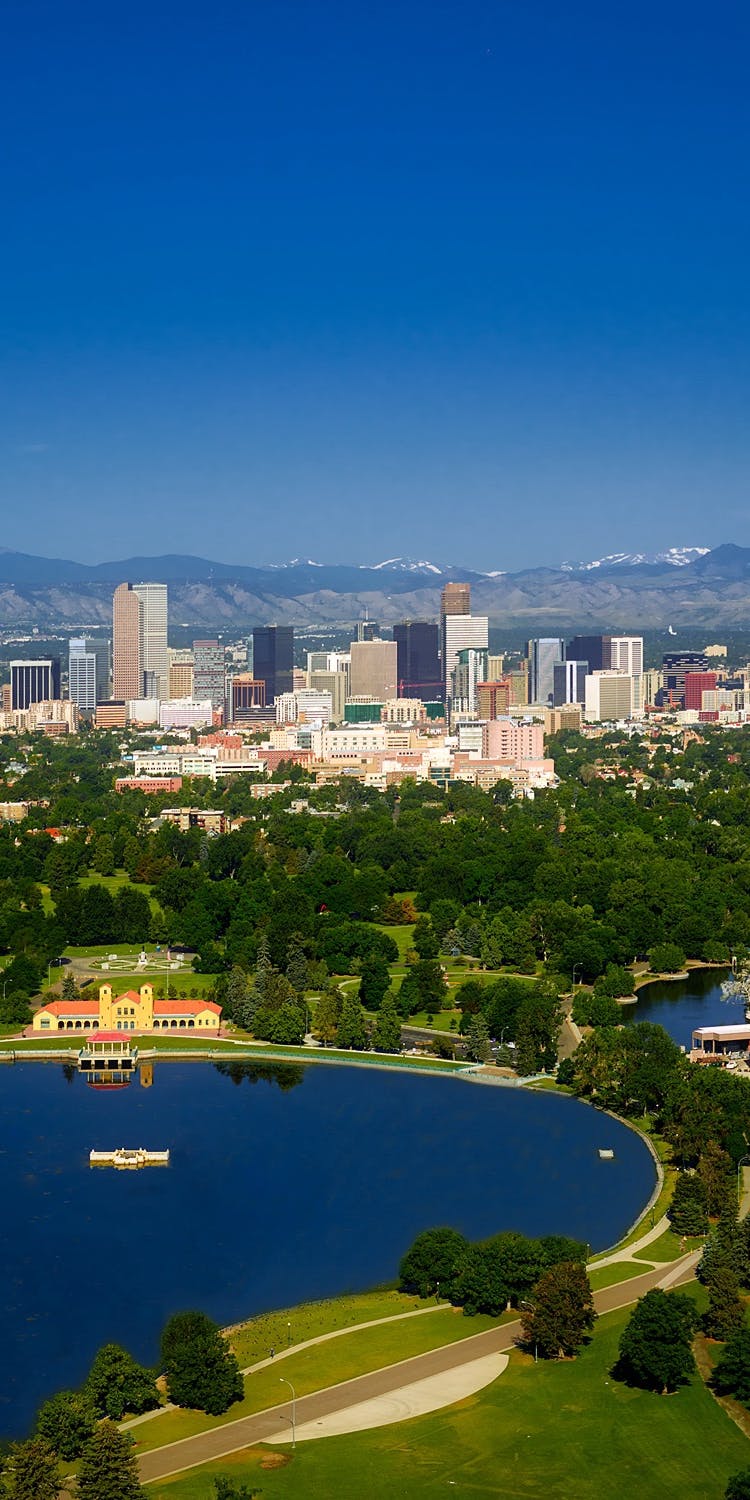 View of downtown Denver with snow-capped mountains in the distance View of downtown Denver with snow-capped mountains in the distance