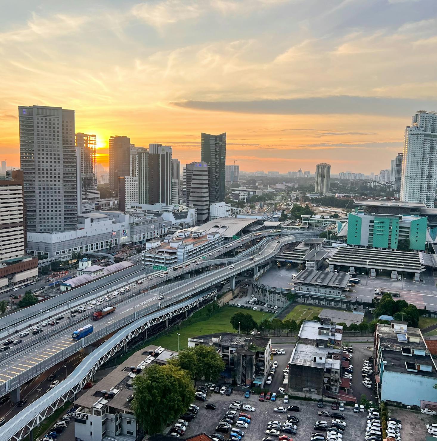 Tall buildings and busy roads of Johor Bahru at sunset