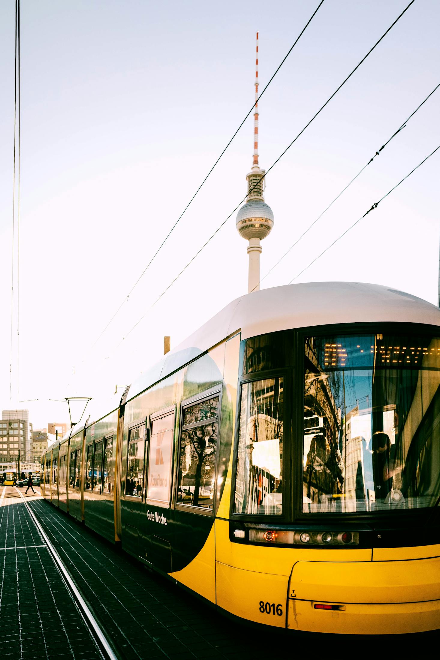 A yellow tram stopped at Alexanderplatz Station in Berlin