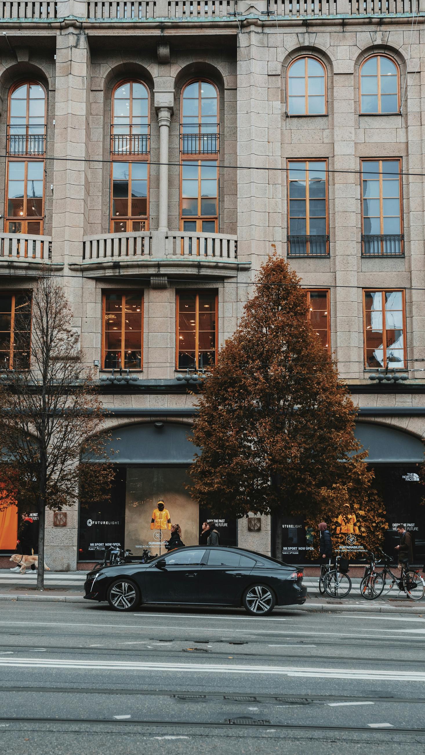 A storefront on a street in Stockholm with a car parked in front