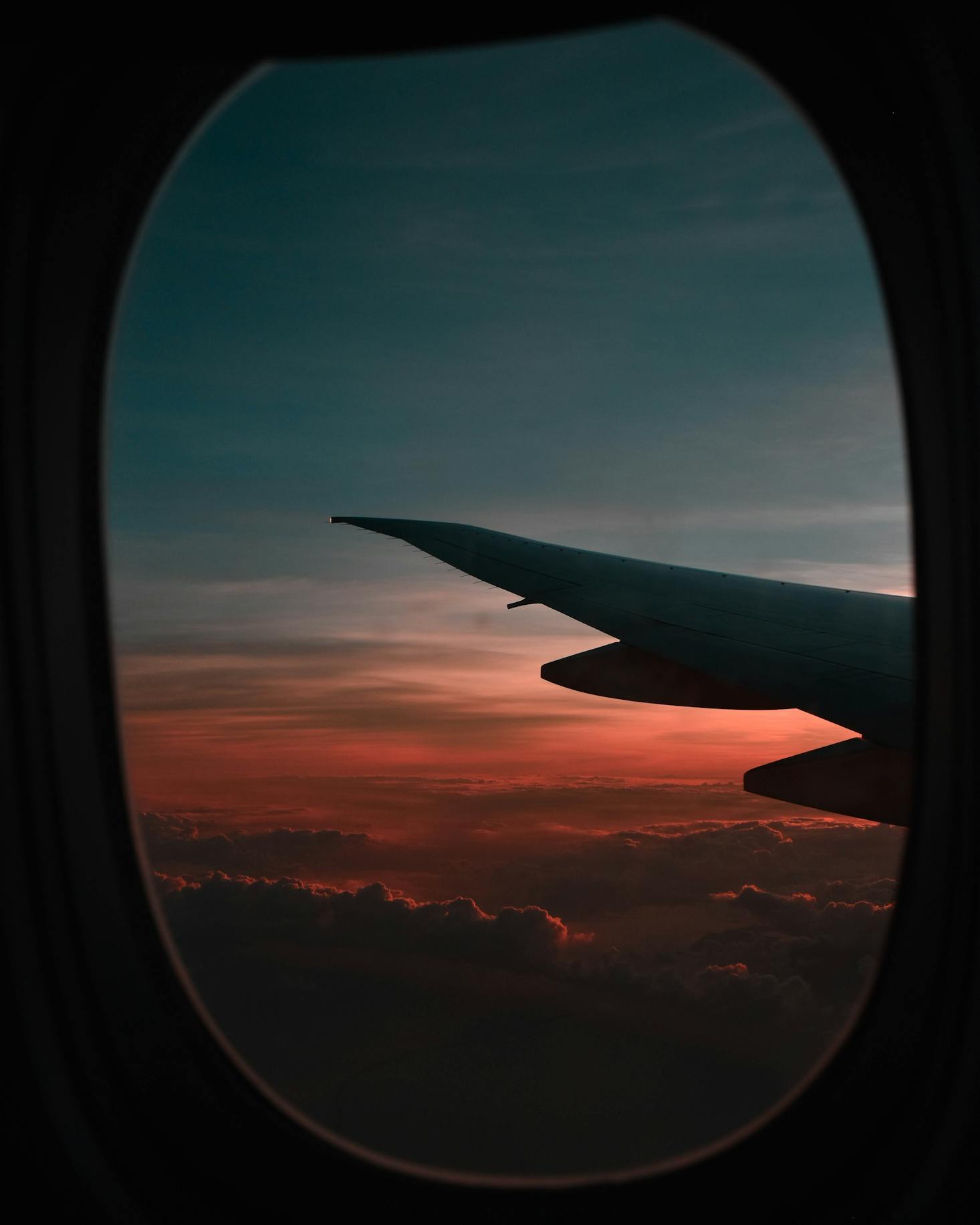 Looking out a plane window at sunset flying over Rome Airport