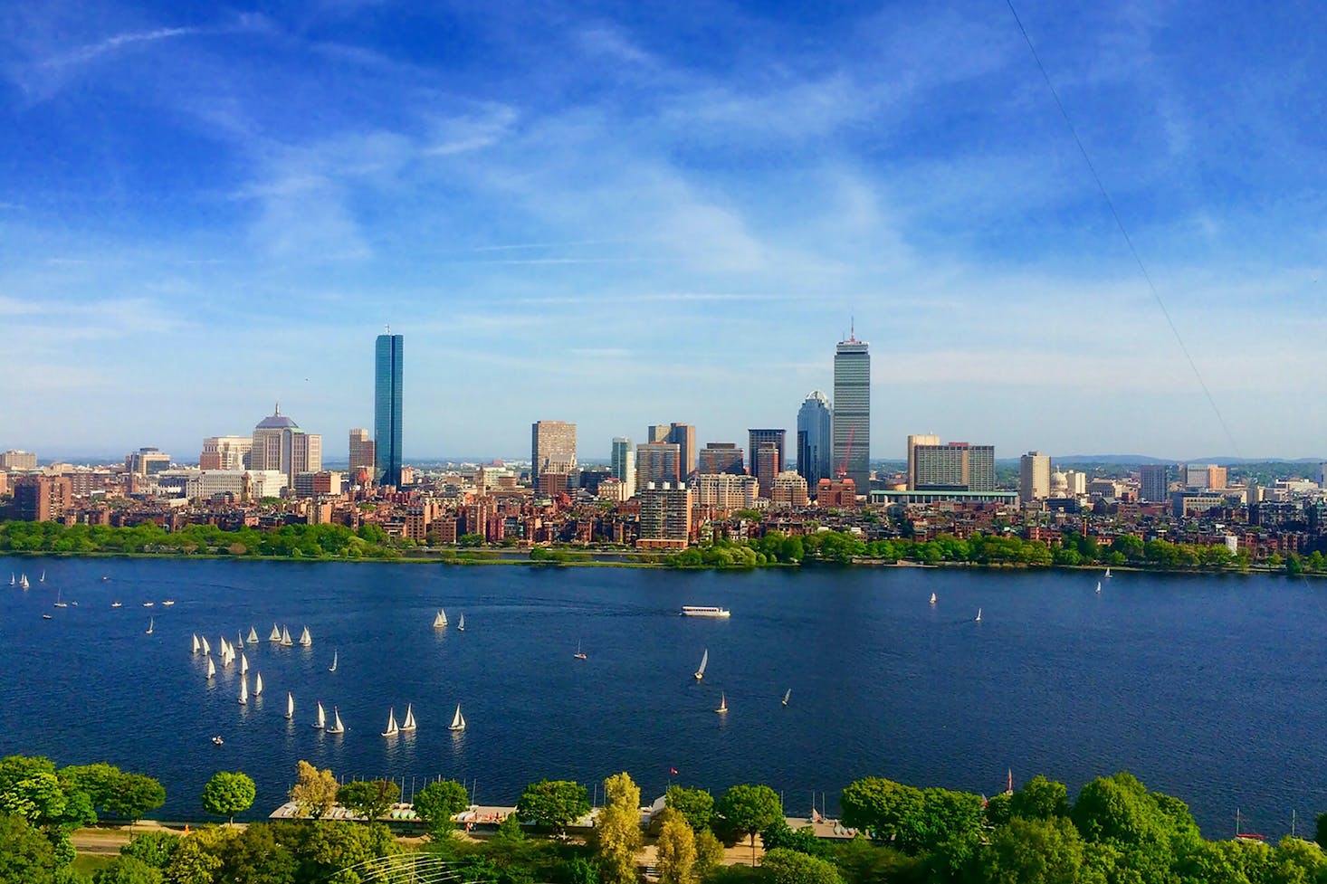 The Boston Harbor on a sunny day with the city's skyscrapers in the distance