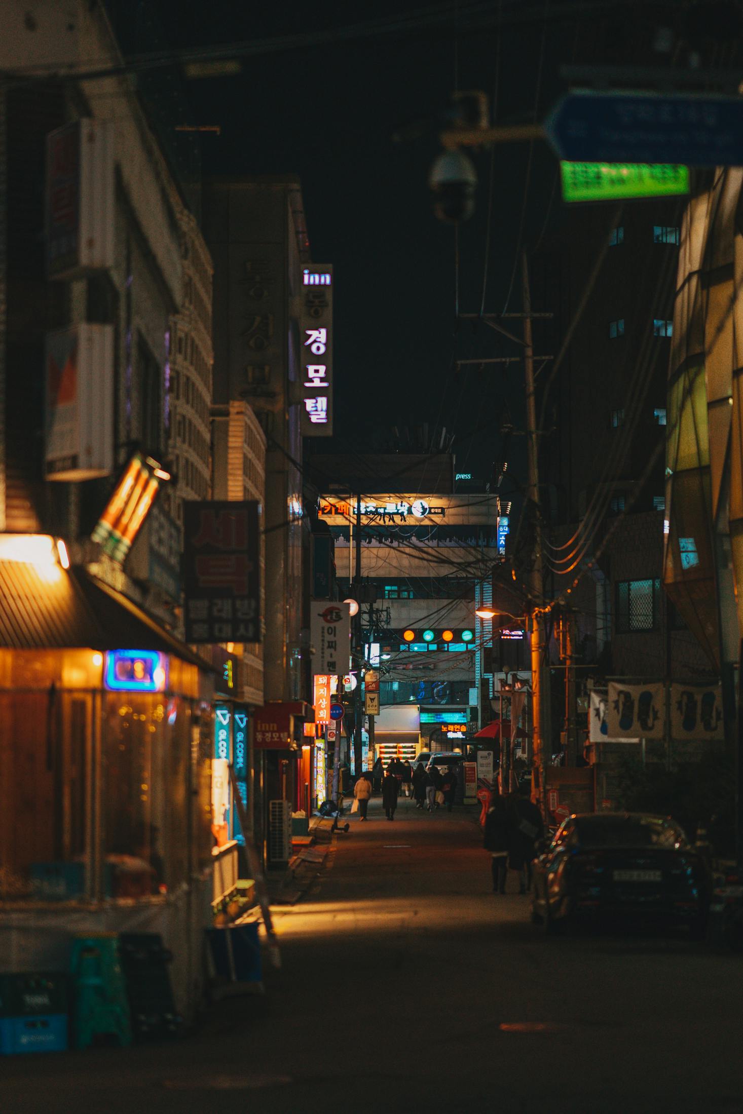 The busy area of Hongdae in Seoul at night with many signs for shops and restaurants