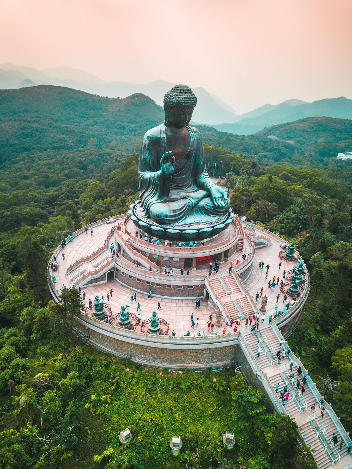 Visitors climb the stairs to the Tian Tan Buddha in Hong Kong, surrounded by lush forests