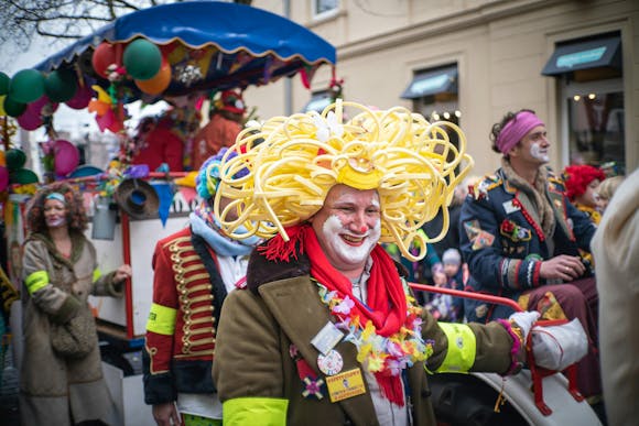 Colorful crowd in costumes and marching bands celebrating outdoors