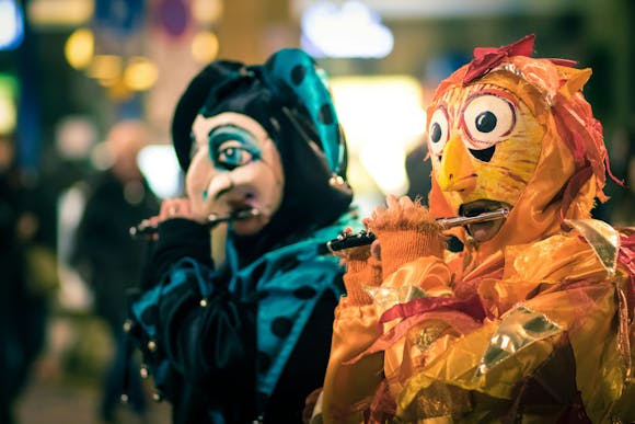 Two masked parade participants playing piccolos