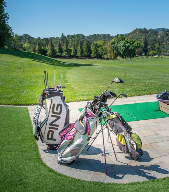 Golf equipment on a lush green golf field during a bright and sunny day