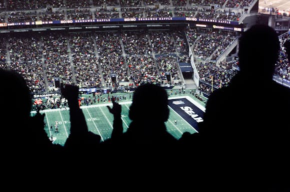 Fans packed in the stadium stands, cheering and watching the action at Super Bowl