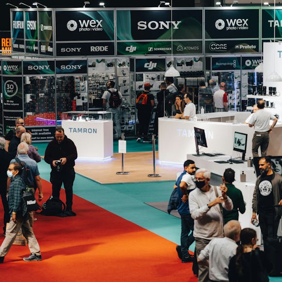 Crowded indoor fair, with attendees networking and chatting together