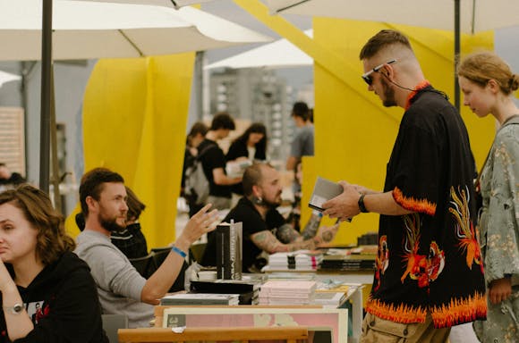 Visitors browsing books, attending author readings, and engaging in literary discussions at the Leipzig Book Fair