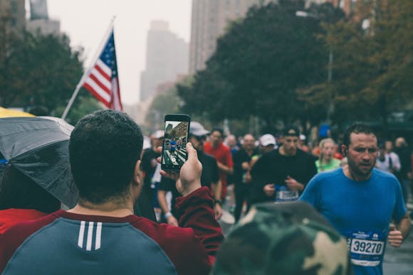 A spectator of the Marathon de Paris taking a photo of the runners