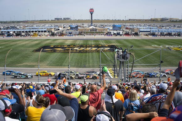 A spectator's view from the seats during a race, with stands packed with enthusiastic fans