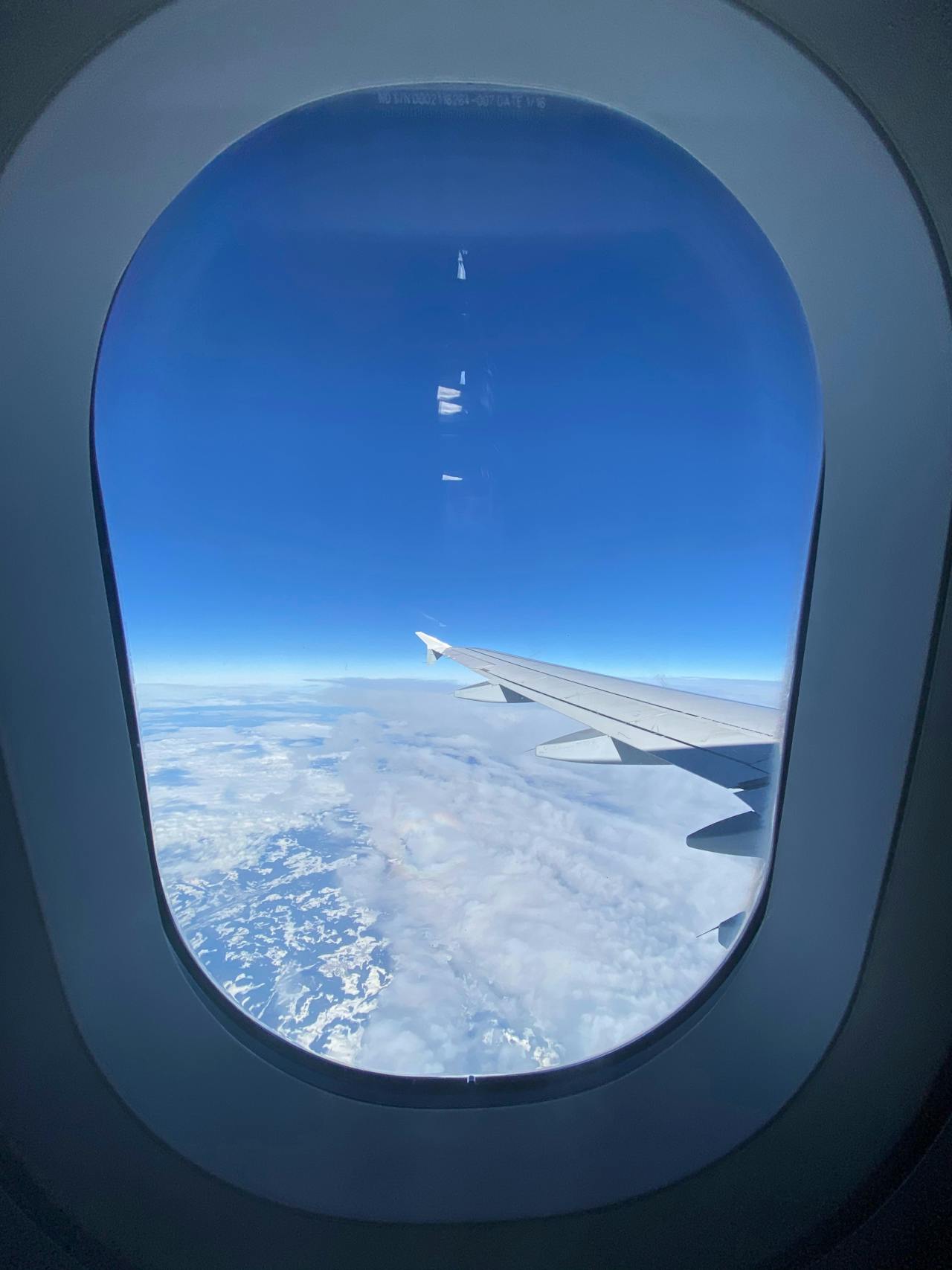 View through the plane window above the clouds near Munich Airport