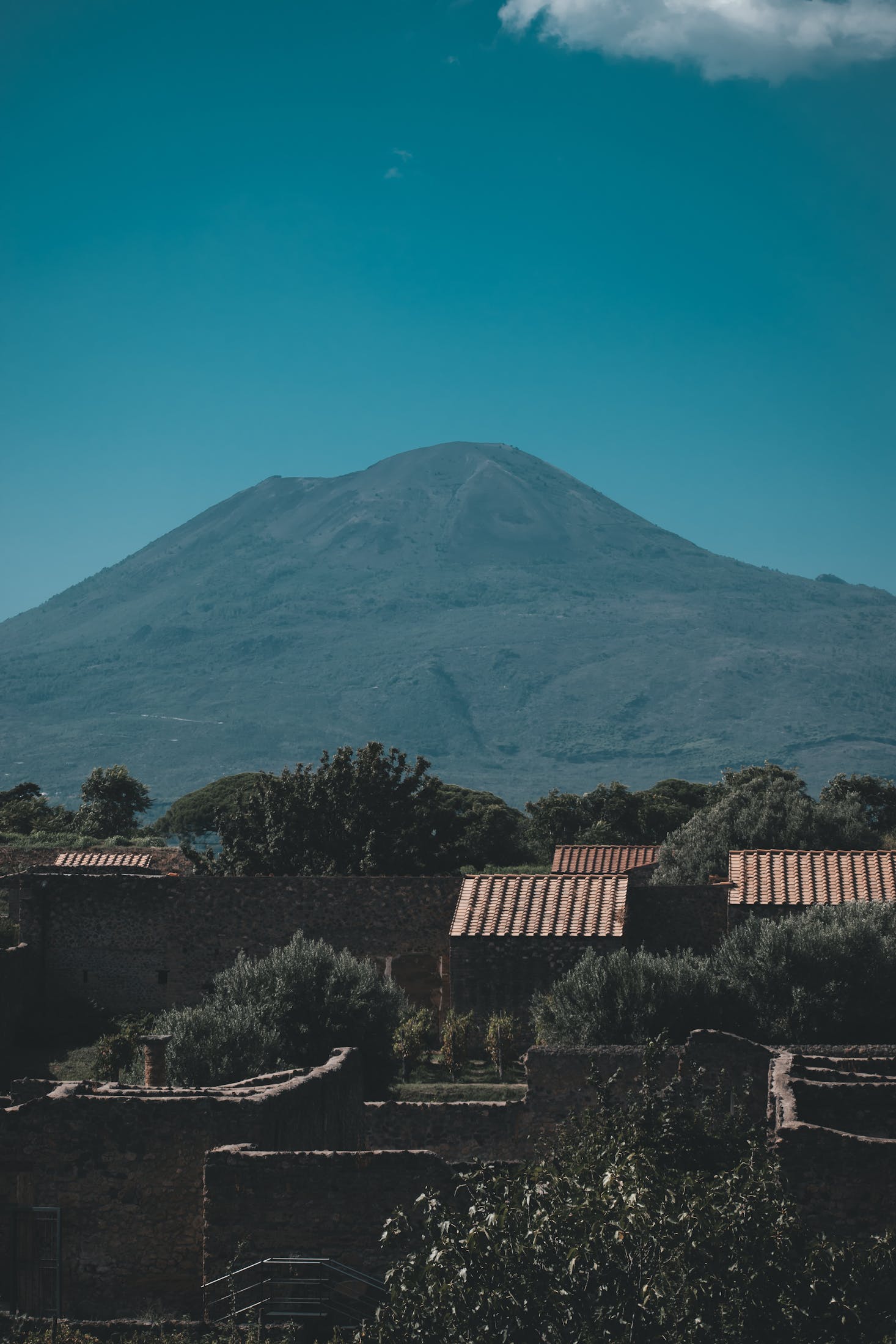 Mount Vesuvius is highlighted against a turquoise sky in Pompeii, Italy